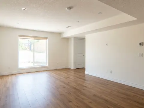 After: Finished basement room with wood-look flooring